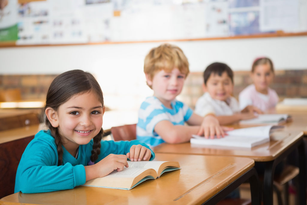 a class of primary children smiling at the camera