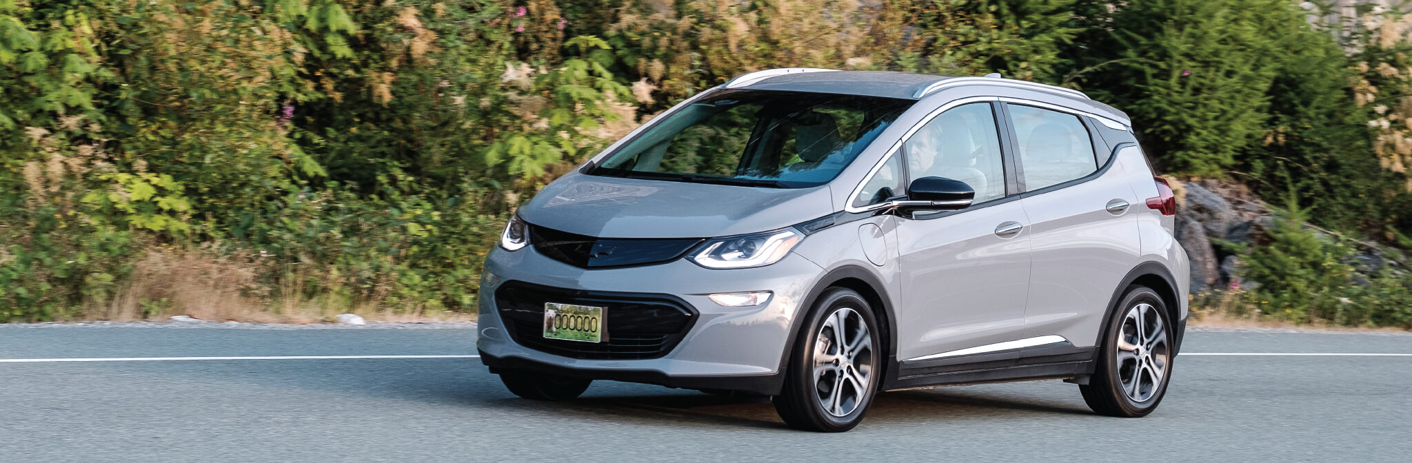 picture of a grey electric car on the road in the countryside