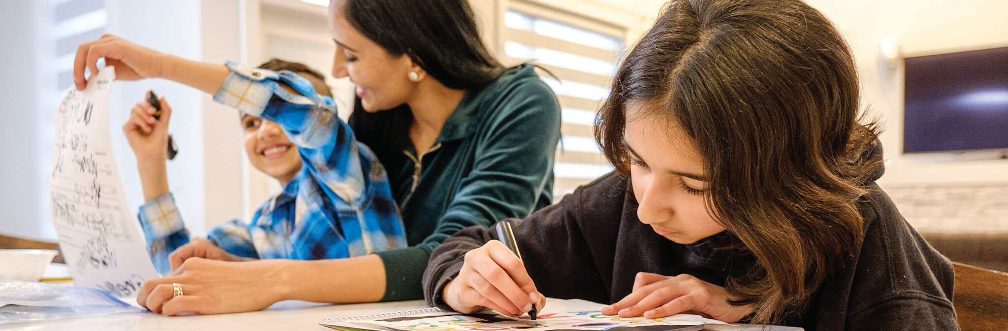 a mother helping her children doing their homework