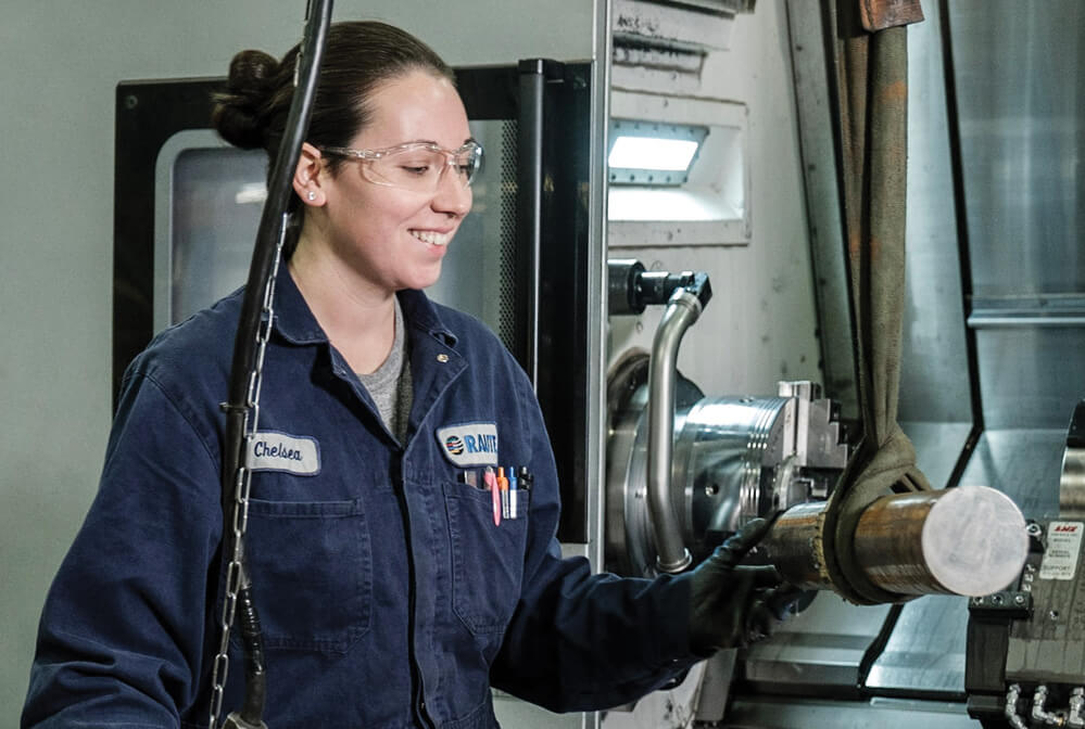 a woman in her blue overalls working in an industry