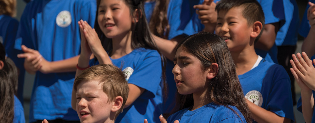 a group of school chldren clapping their hands