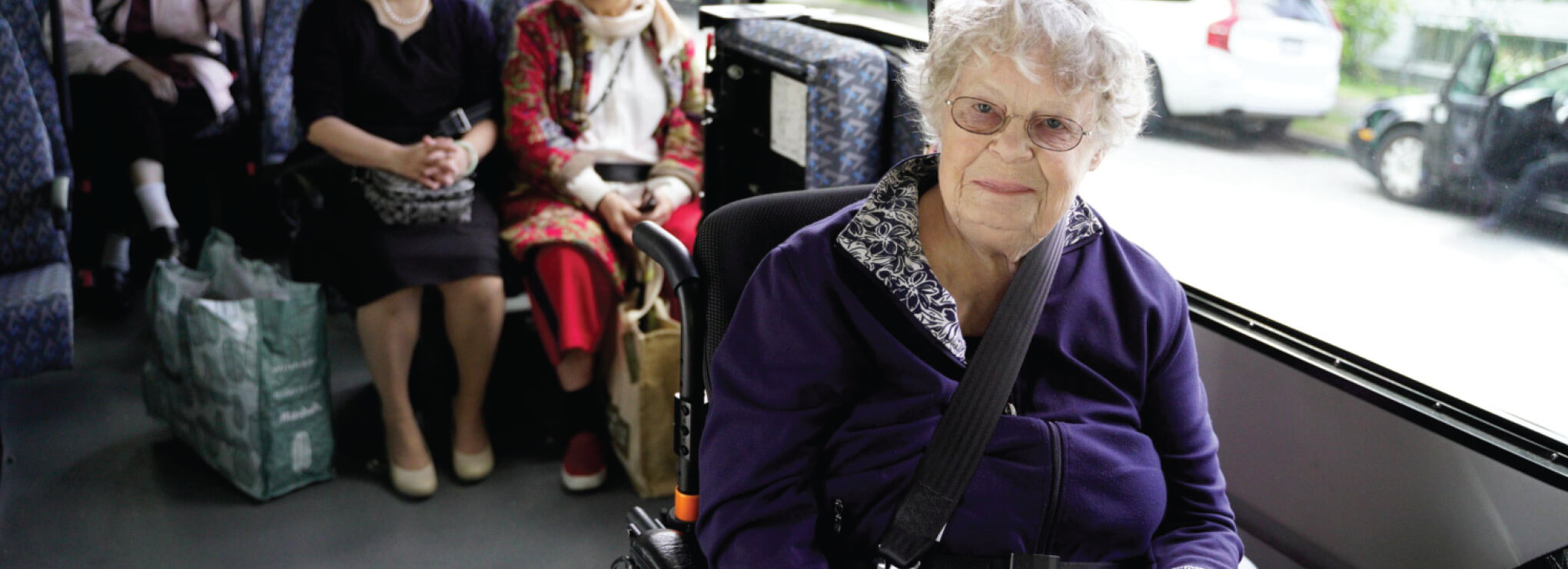 a group of elderly person seated in a bus ride