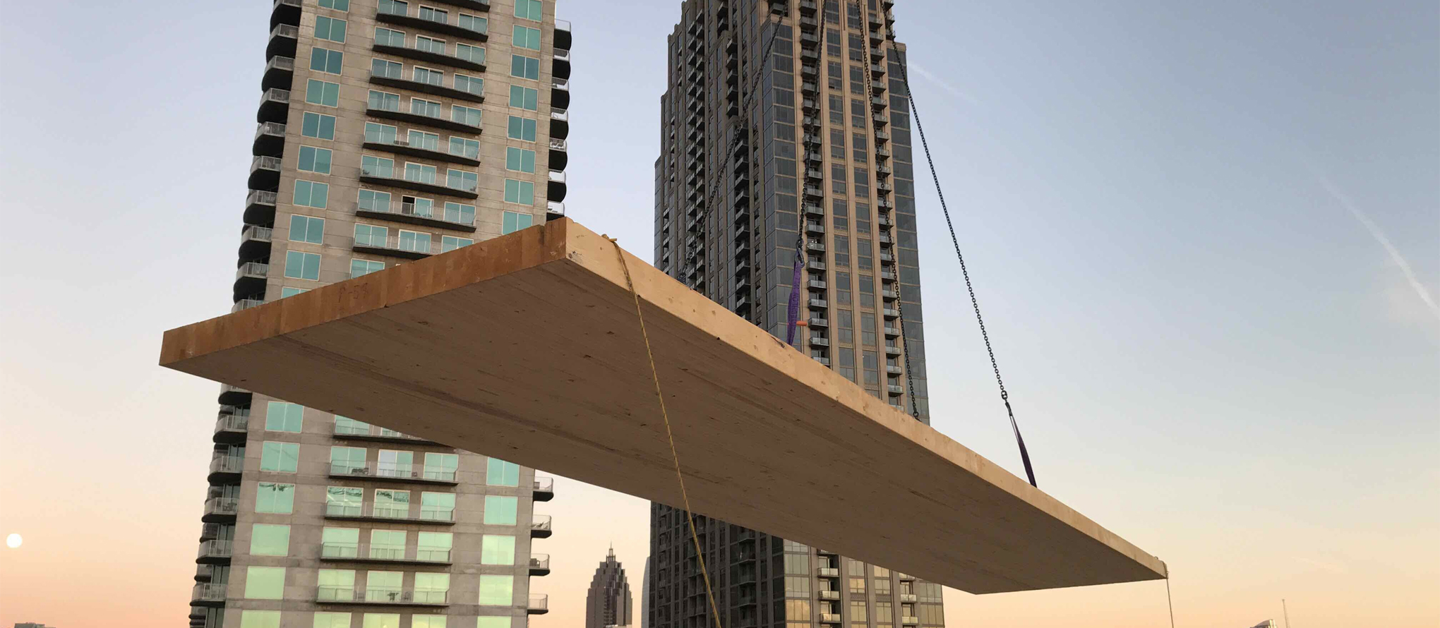 lumber being lifted by crane at city construction site