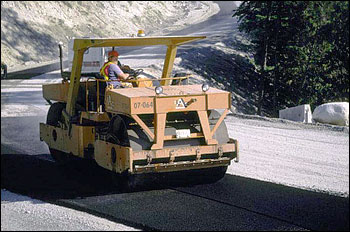 A compaction roller compacting freshly laid asphalt.